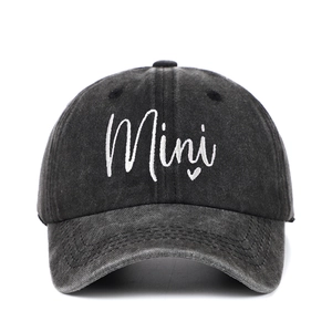 Macro detail of 'Mini' white embroidery with heart on grey washed denim baseball cap