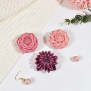 Detail view of pink and purple floral wax melts with elegant pearl gold earrings