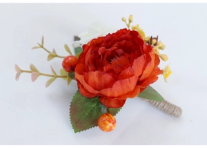 Macro shot of handmade red silk rose boutonniere with green leaves and rustic hemp rope stem
