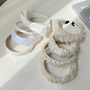 Elegant Korean style pearl and lace headbands with bow details on white surface