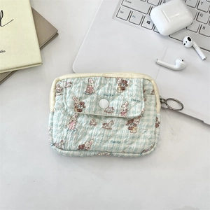 Detail of quilted mini organizer bag featuring cute animal prints on blue checkered fabric