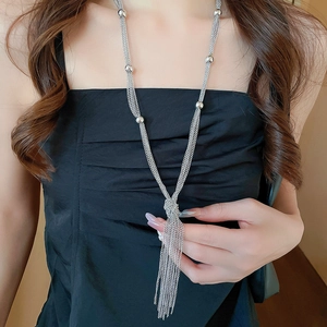 Silver multi-strand chain necklace featuring a knotted tassel pendant on black fabric