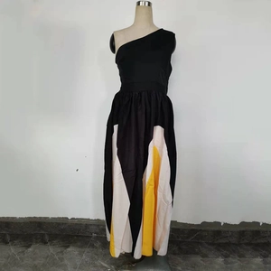 Detail of off-shoulder maxi dress with black bodice and yellow-white geometric patchwork