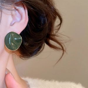 Detail of dark green enamel earrings with gold plating on irregular geometric shape