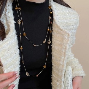 Detaillierte Nahaufnahme einer Vintage-Perlenkette mit Tigerauge-Steinen und Goldakzenten