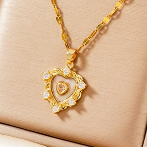 Dettaglio della collana con ciondolo a cuore dorato con madreperla e pietre di zircone