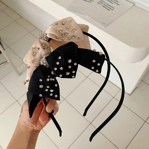 Detalle de elegantes diademas con lazo y diamantes de imitación en negro y champán