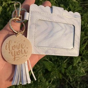 Close-up of white leopard pattern ID card holder with tassel and gold keychain detail