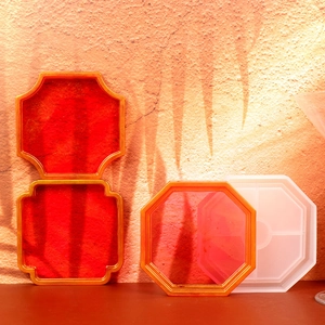 Detail of Chinese window-shaped resin molds with gold-edged red finished coasters