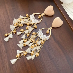 Macro detail of French vintage heart beads and golden chain tassels on bohéme earrings