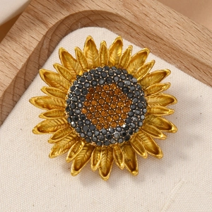 Detailed close-up of a sunflower brooch with golden textured petals and crystal center