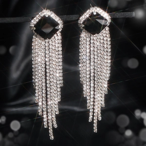 Detailed close-up of luxury tassel earrings featuring black stones and sparkling crystals