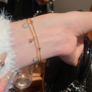 Detailed close-up of 18k gold plated double-layer heart bracelet with zircon stones