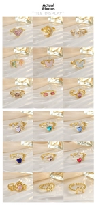 Macro display of diverse gold-plated rings with colorful zircon heart and star patterns