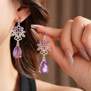 Macro shot of purple teardrop earrings with silver metal inlay and sparkling crystals
