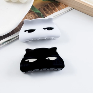 Cute black and white cat shaped hair claws set on a white desk with aesthetic props