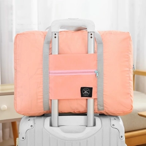 Portable orange travel storage bag with suitcase handle sleeve and mountain logo patch