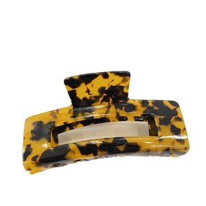 Classic tortoise shell acetate rectangular hair claw clip with cutout design on white background