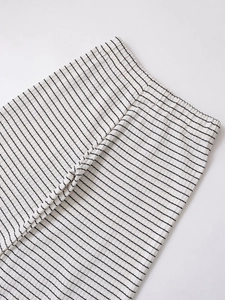 Détail du pantalon en tricot rayé noir et blanc avec texture côtelée et taille élastique