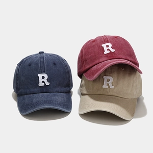 Detailed embroidery of letter R on vintage washed cotton baseball caps in three colors