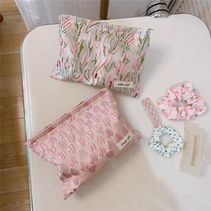 Close-up of pink heart and floral jacquard cosmetic bags with a simple wish fabric label