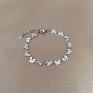 Macro detail of silver butterfly link bracelet in stainless steel with lobster clasp