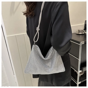 Silver rhinestone mesh shoulder bag featuring a knotted strap detail on the model