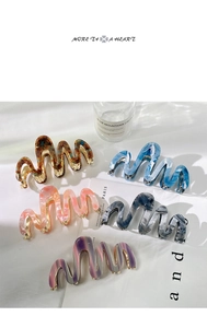 Detailed view of wave-shaped acetate hair claws with marble texture in multiple colors