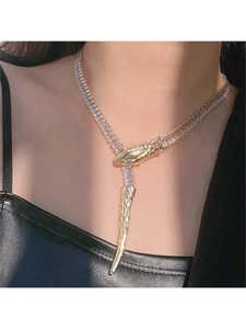 Detail of shimmering gold snake bone necklace with baguette zircon worn by female model