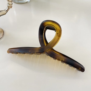 Detail view of a 15cm tortoise shell resin hair claw clip with amber texture finish