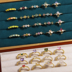 Elegant collection of zircon and pearl rings in various colors displayed in a jewelry box