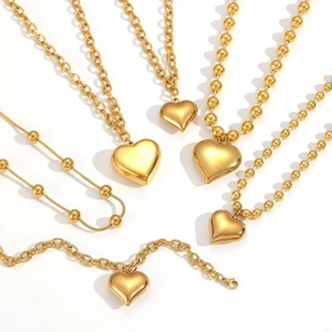 Golden stainless steel jewelry set featuring heart pendants and beaded chain necklaces