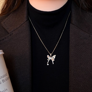 Close-up of elegant gold butterfly necklace with colorful zircon stones on model