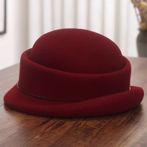 Detail of burgundy wool felt bowler hat with elegant rolled brim and black bead chain