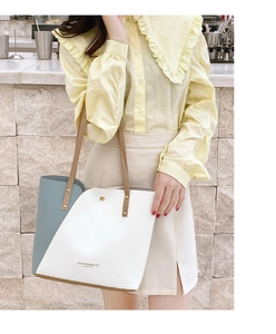 Three-color patchwork tote bag with fashion leather embossing on a marble surface