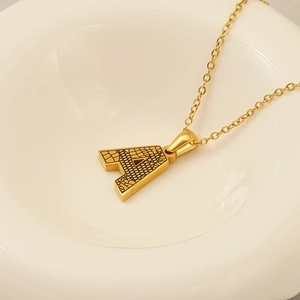 Gros plan d'un pendentif lettre A doré avec une texture d'écorce sophistiquée