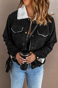 Detail of black corduroy jacket showing white sherpa fleece collar and texture