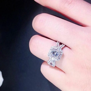 Elegant engagement ring with square-cut zircon and double-row pavé diamond band on finger