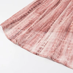 Dettaglio dell'orlo del vestito in chiffon tie-dye rosa con cucitura fine arrotolata