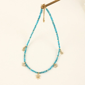 Detailed view of bohemian blue stone necklace with gold zircon charms and beads