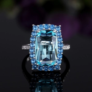 Détail macro d'une bague zircon bleu ciel avec halo d'argent et anneau pavé