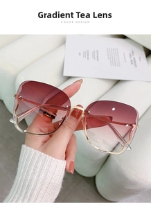Close-up of rimless butterfly sunglasses with gradient tea lenses and gold metal frames