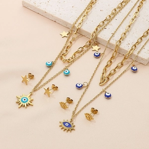 Parure de bijoux dorée avec colliers et boucles d'oreilles œil sur pierre crème