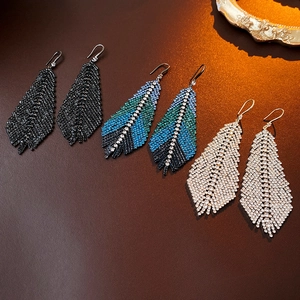Three pairs of crystal feather tassel earrings in black, blue-green, and silver options