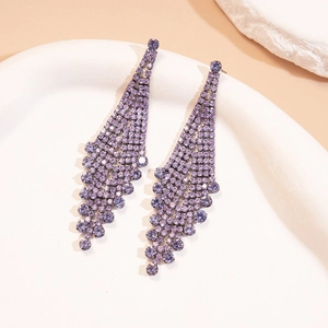 Detailed view of elegant purple rhinestone long tassel drop earrings on white ceramic tray