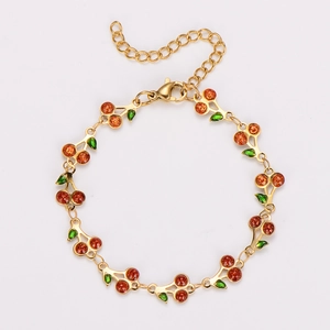 Detail of bohemian cherry bracelet with orange resin beads and green enamel leaves