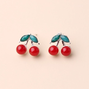 Close-up of stylish 3D cherry earrings with red fruit charms and green leaf detail