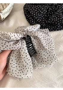 Detail of French retro polka dot chiffon bow hair claw clips in black and white colors