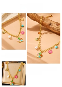 Detail view of gold chain necklace with colorful resin flowers and pearl charms