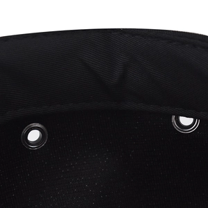 Dettaglio dei passanti in metallo e cuciture rinforzate su un cappellino in cotone nero